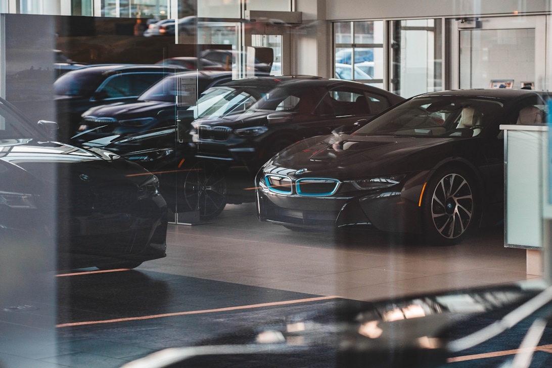 Interiör av en ljus och modern bilhall med BMW-bilar på ett polerat golv.